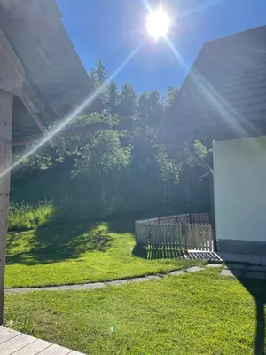 a sun shining on a yard with a fence at Gorjuška Rozamunda in Bohinjska Bistrica