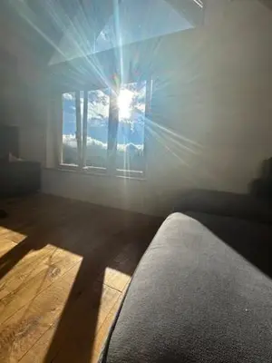 a room with a window with the sun shining through at Gorjuška Rozamunda in Bohinjska Bistrica