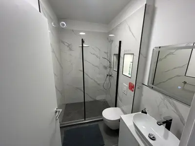 a bathroom with a shower and a toilet and a sink at CASA BOX APARTMENT Free garage in Maribor