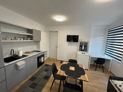 a kitchen and living room with a table and chairs at CASA BOX APARTMENT Free garage in Maribor