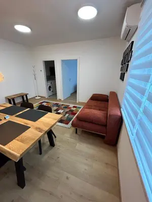 a living room with a table and a couch at CASA BOX APARTMENT Free garage in Maribor
