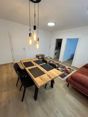 a dining room with a table and a couch at CASA BOX APARTMENT Free garage in Maribor