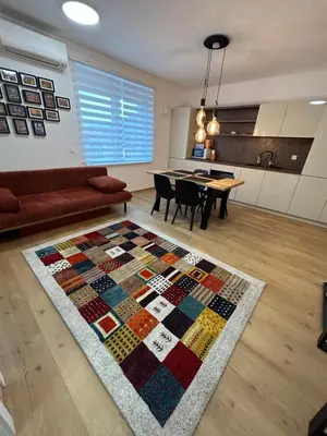 a living room with a quilt rug on the floor at CASA BOX APARTMENT Free garage in Maribor