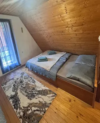 a bedroom with two beds in a wooden cabin at Chalet SS Pohorje in Pohorje
