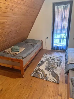 a bedroom with a bed and a rug and a window at Chalet SS Pohorje in Pohorje