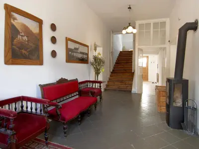 a living room with two red chairs and a fireplace at The old Village Villa At 2 Geese with Pool in Pišece