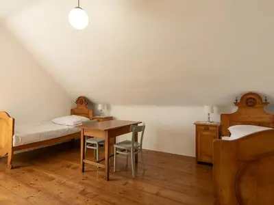 a bedroom with a bed and a desk and a bed and a table at The old Village Villa At 2 Geese with Pool in Pišece