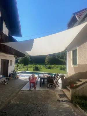 a patio with a table and chairs and a pool at The old Village Villa At 2 Geese with Pool in Pišece