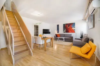a living room with a staircase and a living room at City Central Ljubljana in Ljubljana