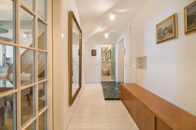 a hallway with white walls and a long wooden bench at City Central Ljubljana in Ljubljana