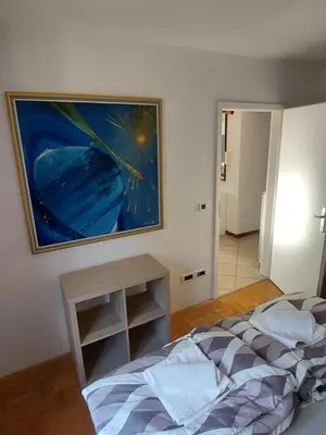 a bedroom with a bed and a painting on the wall at Apartma MILA in Šempas