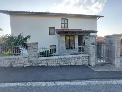 a white house with a fence in front of it at Apartma MILA in Šempas