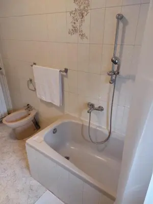 a white bathroom with a tub and a toilet at Apartma MILA in Šempas