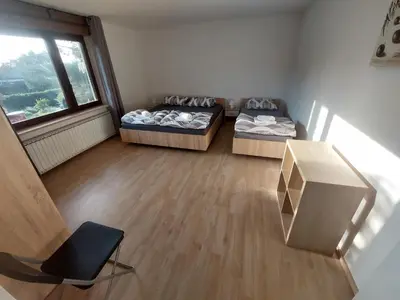 a room with two beds and a desk and a window at Apartma MILA in Šempas