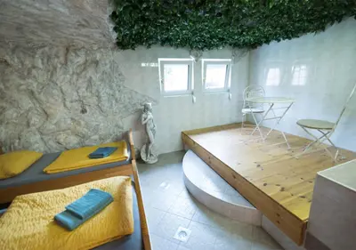 a room with a bed and a table in a cave at Klub Zlata Ribica in Jesenice