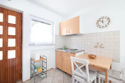 a kitchen with a wooden table and a counter top at Klub Zlata Ribica in Jesenice