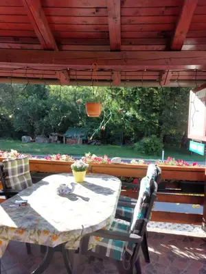 a table and chairs sitting under a wooden roof at Apartment Stefka in Kranjska Gora