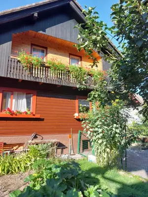 an orange house with a balcony with flowers on it at Apartment Stefka in Kranjska Gora