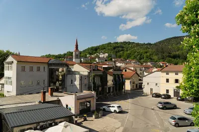 a view of a town with cars parked in a parking lot at Sobe in apartmaji Triglav - Gostinstvo Tomex in Ilirska Bistrica
