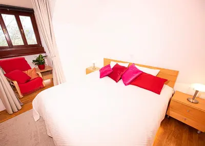 a bedroom with a white bed with red pillows at Heart Bled in Bled