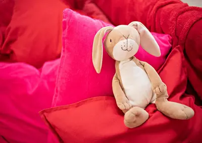 a stuffed rabbit sitting on a red couch at Heart Bled in Bled