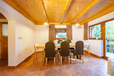 a dining room with a wooden table and chairs at Holiday Home Emaj with Sauna in Krška Vas