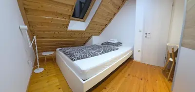 a bed in a room with a wooden ceiling at Holiday Home Emaj with Sauna in Krška Vas