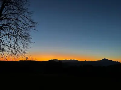 a sunset with mountains in the background at Apartment and rooms Špes in Mislinja