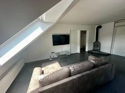 a living room with a couch and a flat screen tv at Apartment and rooms Špes in Mislinja