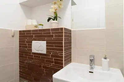 a bathroom with a white sink and a brick wall at Central Castle Apartments in Ljubljana