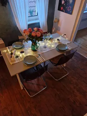 a table with plates and a vase of flowers on it at Apartma Nara in Ljubljana