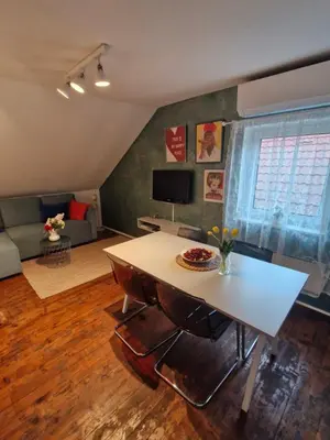 a living room with a table and a couch at Apartma Nara in Ljubljana