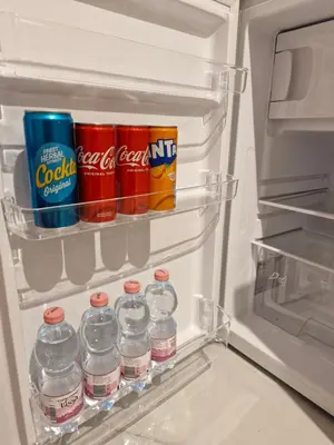 an open refrigerator filled with drinks and cans of soda at Apartma Nara in Ljubljana