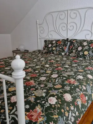 a bedroom with a bed with a floral bedspread at Apartma Nara in Ljubljana