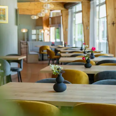 a row of tables and chairs with vases with flowers on them at Appartments Vrba, Terme Snovik in Laze v Tuhinju