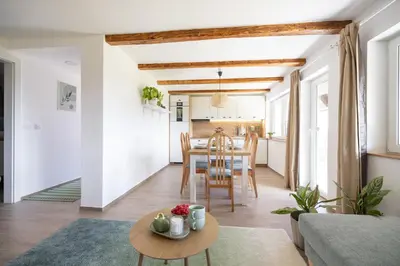 a living room and kitchen with a table and chairs at Hiška ViSa in Šoštanj