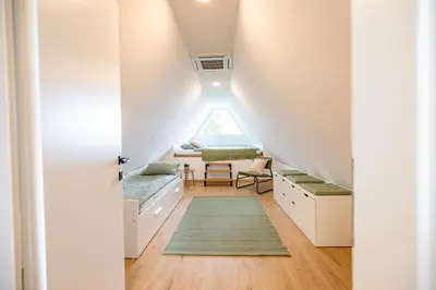 a room with a window and a bed with a table at Hiška ViSa in Šoštanj
