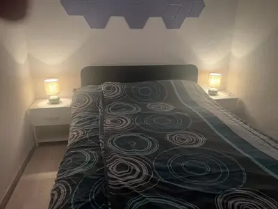 a bedroom with a bed with two lights on it at Apartment Romeo & Julija, Near terme Olimia, Free Parking in Podčetrtek