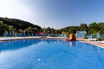 a large swimming pool with chairs and a slide at Apartment Romeo & Julija, Near terme Olimia, Free Parking in Podčetrtek