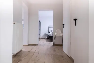 a hallway with white doors and a wooden floor at Green Street Hideaway in Šempeter v Savinjski Dolini