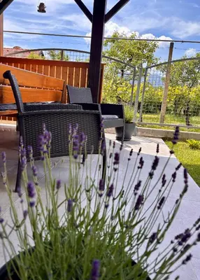 a patio with a table and chairs and purple flowers at Green Street Hideaway in Šempeter v Savinjski Dolini