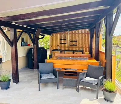 a patio with two chairs and a wooden bench at Green Street Hideaway in Šempeter v Savinjski Dolini