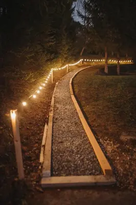 a pathway with lights on the ground at night at Zasebna hiša v naravi s savno, hiša 14H in Laško