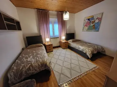 a bedroom with two beds and a window at Apartma ob meji in Šempeter pri Gorici