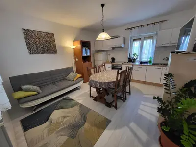a kitchen and living room with a couch and a table at Apartma ob meji in Šempeter pri Gorici