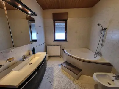 a bathroom with a tub and a sink and a bath tub at Apartma ob meji in Šempeter pri Gorici