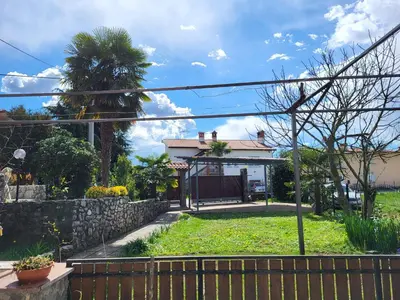 a house with a fence and a yard at Apartma ob meji in Šempeter pri Gorici