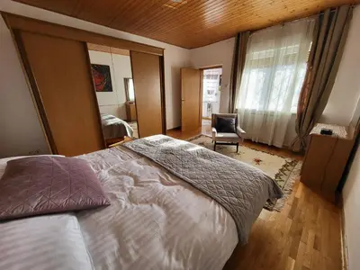 a bedroom with a large bed and a chair at Apartma ob meji in Šempeter pri Gorici