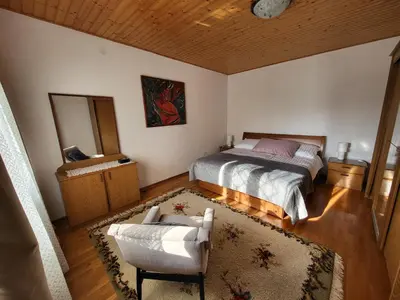 a bedroom with a bed and a chair and a mirror at Apartma ob meji in Šempeter pri Gorici