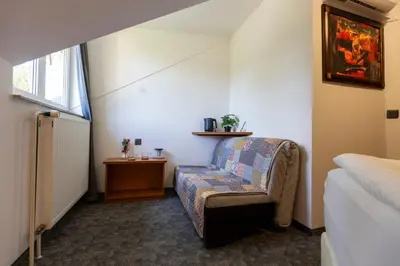 a room with a chair and a bed and a window at Brezov kot in Jesenice